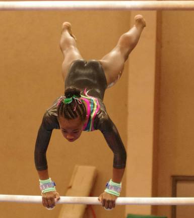Westys (Franklin Borough, N.J.) gymnast OLIVIA FISHER (10) performes on the uneven bars. Fisher placed first in her age group on Vault with an 8.1 and on Balance Beam with an 8.05.
