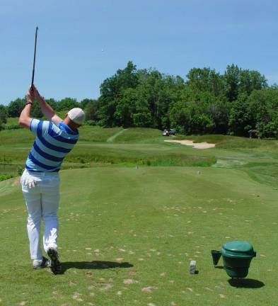 Mike Cohen hits his tee shot using a vintage hickory stick golf club at the par 3 11th hole of the Ballyowen Golf Course