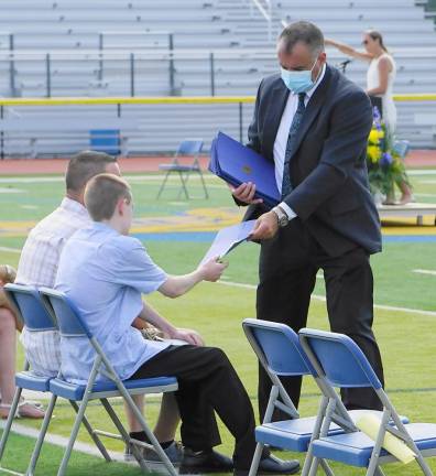 On right, Assistant Principal Eric Kosek gives a student his certificate. (Photo by Vera Olinski)