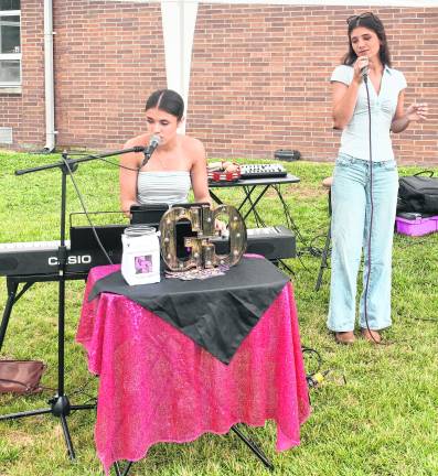 Chloe and Lily Geuther sing.