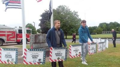 Wallkill Valley FBLA co-presidents Brian Hall (left) and Joey Mueller display veteran recognition signs at the Ogdensburg Firehouse on Memorial Day (Photo provided)