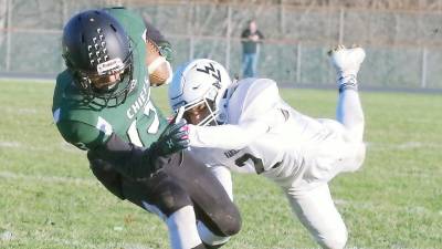 Hopatcong ball carrier Brandon Rodriguez moves forward as Wallkill Valley defender Romeo Cuevas leaps towards him during a tackle attempt in the second half.