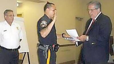 Then-Mayor Vic Marotta swears in Patrolman Emanuel Rivera at an August 2013 township council meeting as Chief Roy Wherry looks on. (File photo by Mike Zummo)