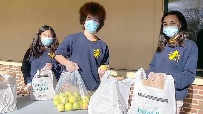 Project Self-Sufficiency Youth Corps members (from left): Kelly Tapia, Xavier Gonzalez and Adrianna Smith help bag turkey dinners (Photo by Laurie Gordon)