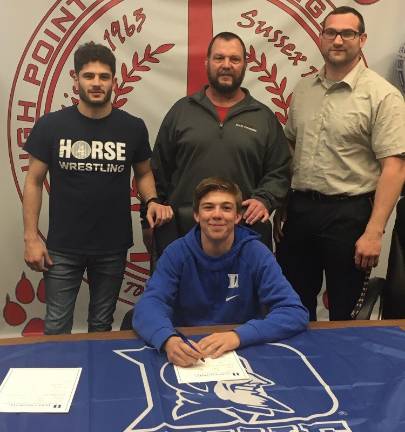 High Point's Brandon LaRue, seated middle, signs his National Letter of Intent to continue his wrestling career at Duke University. Pictured with Brandon are - seated from left to right: mother Leslie LaRue, Brandon, and sister Kaitlyn. Standing in the middle row: sister Mackenzie and brother Cameron, and back row from left to right: Father Jason LaRue, Assistant Coach Billy Smith and Head Coach John Gardner.
