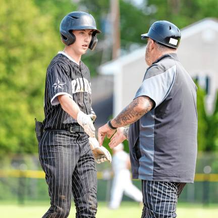 After singling to right-centerfield, Ryan Miller is greeted by his first base coach in the top of the first inning.
