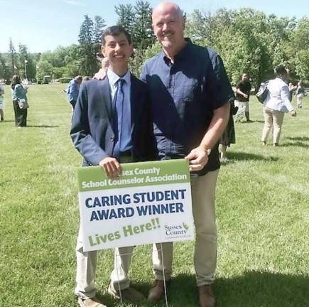 Ian Philback and Hardyston Chief School Administrator Mark Ryder stand in front of a signing indicating that a “caring student” lives inside.