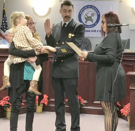 Municipal Clerk Darlene Tremont, right, administers the oath of office to Fire Chief Khyle Conklin.