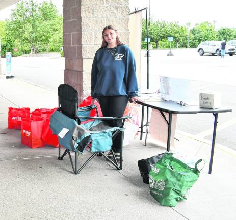 Volunteer Magee Costello poses with bags that were collected.