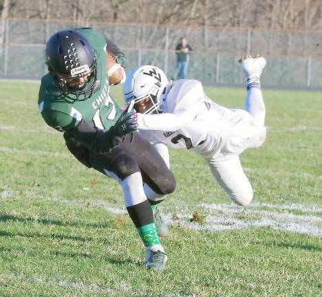 Hopatcong ball carrier Brandon Rodriguez moves forward as Wallkill Valley defender Romeo Cuevas leaps towards him during a tackle attempt in the second half.