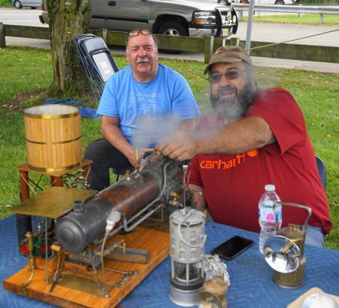 From left, Bill Kroth and Fred Lubbers demonstrate a steam engine and generator.