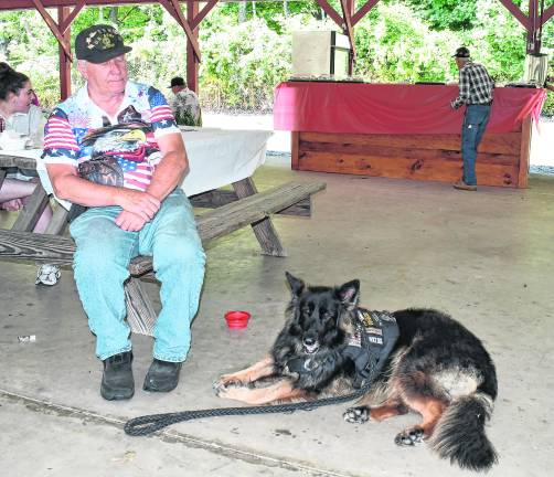 Ken Augustin of Newton sits with his dog, Remy.