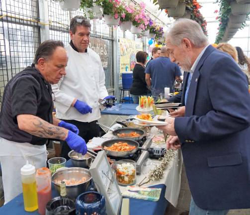 The Lamp Post Inn Chef serves Alaska Shrimp and Chicken Spicy Jumbalaya to a guest.