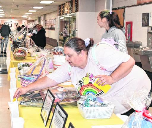 Hailey Babcock of Harydston places a ticket in a bag as Laurielei Gomolla of Newton looks at the table. About 250 tickets were sold.