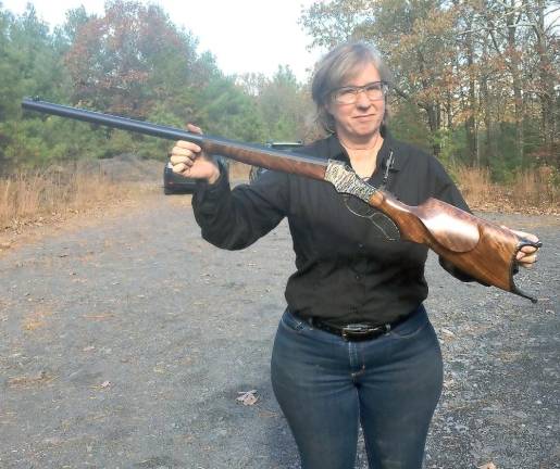 Gail holding a finished rifle: lock, stock, and barrel