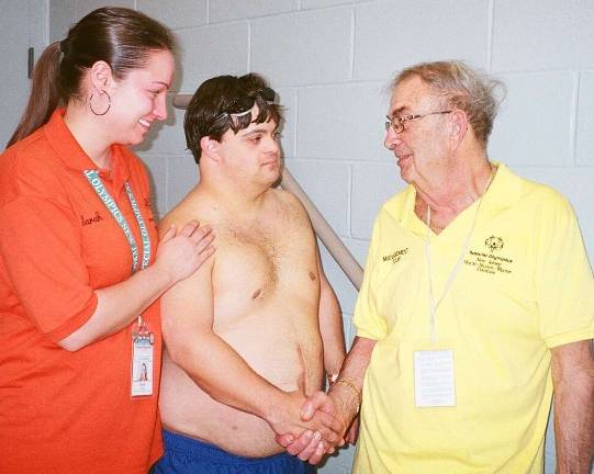 Special Olympics athlete Joe Pezzolla of Newton, center, receives congratulations from Special Olympics volunteer Sarah Enderle of Florham Park and Special Olympics Management Team member Don Verbel of Boonton.