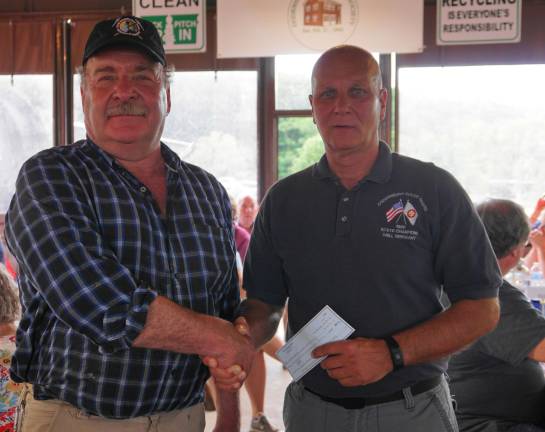 PHOTO BY VERA OLINSKI From left, Sterling Hill Mining Museum President and Executive Director Bill Kroth presents a $2,500 donation to Ogdensburg Volunteer Fire Chief Rick Keslo.