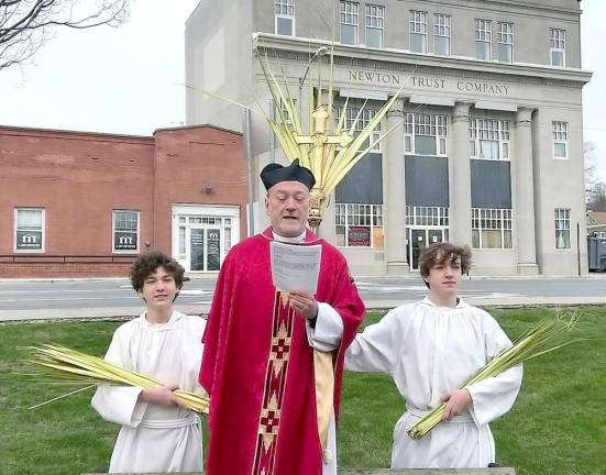 Father Robert Griner delivers the Liturgy of the Palms on the Newton Green with his sons Jesse and Elliott serving as acolytes.