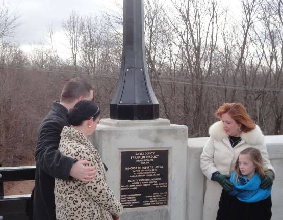 Photo by Scott Baker Virginia "Ginny" Littell, son Luke Littell, daughter Alison Littell McHose, and granddaughter Molly McHose take a moment to read the dedication plaque for the new Viaduct Bridge.