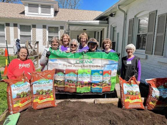 Partnership for Social Service staff members Barbara Gaschler, left, and Laura Mulcahy, right, pose with members of the Snufftown Garden Club.