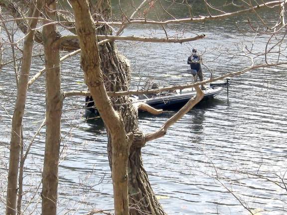 A fisherman relaxes on his boat on Wawayanda Lake.