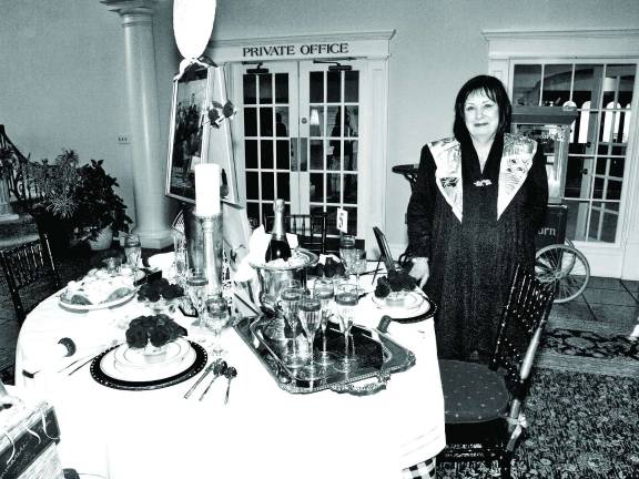 Jacky Murphy stands next to her table she designed based on the movie "Moonstruck". Murphy owns Victory Frame Shop in Lafayette.