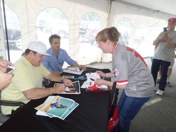 Cathy Bell, of Rock Tavern, Ny, is fully adorned in Reds gear, as she gets an autograph from baseball legend Pete Rose. Photo by Nathan Mayberg,