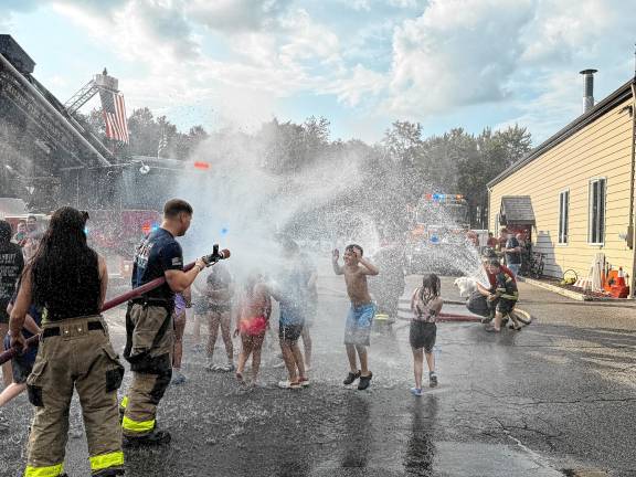 Children play in the water during a wetdown of the new ladder truck Saturday, Aug. 16 at Jefferson Township Fire Department Company 1. (Photos by Denise von Wilke)