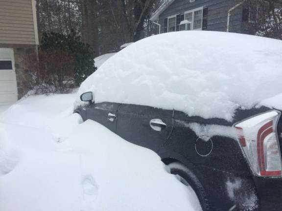A car is buried in Hamburg during Tuesday's storm.