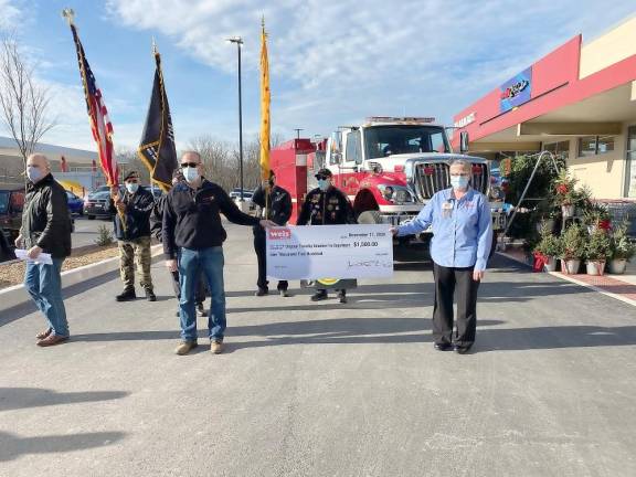 Dennis Curtin (left), director of public relations, Weis Markets; Vietnam Veterans of America, Tri-State Chapter 623; and Amy Zimmerman, store manager, and a store employee holding replica of one of the checks donated to the community groups (Photo by Marilyn Rosenthal)
