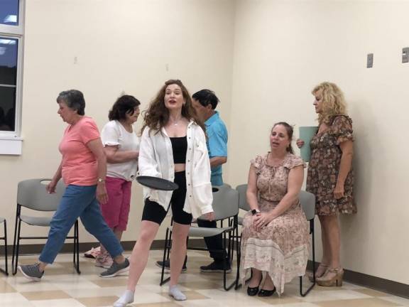 At right, Ginger Reiter, playwright and composer of ‘The Jackie Mason Musical,’ directs the cast in a rehearsal.