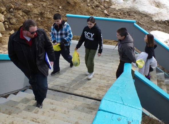 Vernon resident Conor Stanbridge leads kids from the Sussex County YMCA up the stairs to the warm and welcoming lodge for their second skiing lesson.