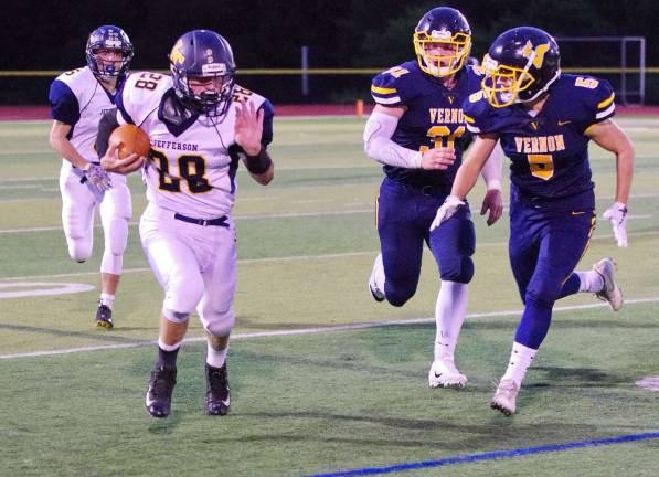 Jefferson ball carrier Michael Fleming is pursued by Vernon defenders.