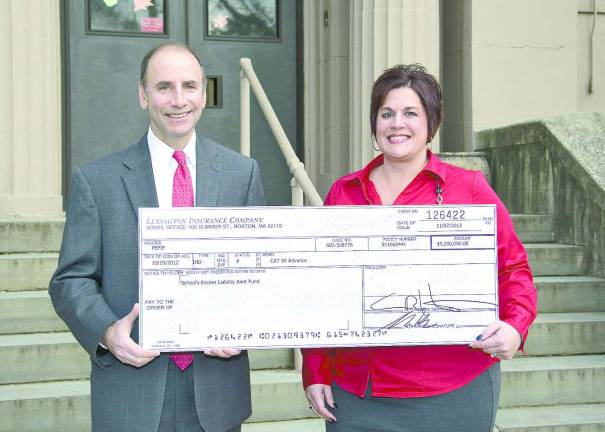 Stephanie Voorhees, chairwoman of SAIF, receives a $5 million check from Lexington Insurance representative Brian Bornstein.