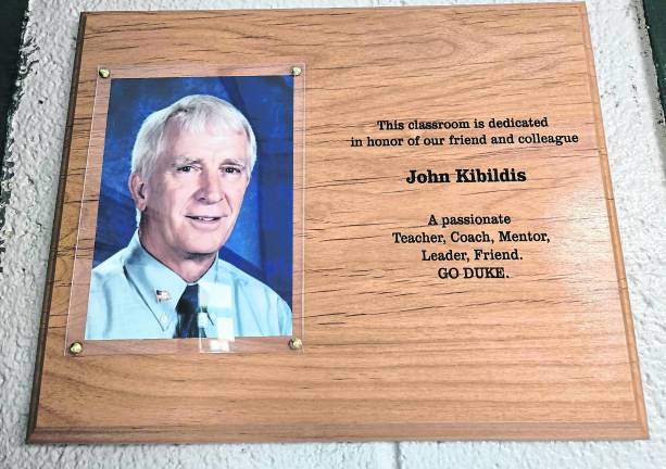 A plaque shown in honor of John Kibildis is shown.
