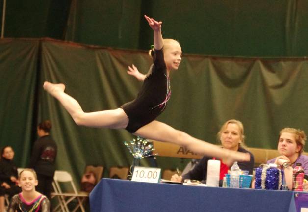 Westys Gymnastics (Franklin Borough, N.J.) athlete CHELSEA SMITH (9) gracefully moves through the air during her floor routine. Smith earned first place on the uneven bars and Balance Beam in her age division both with a score of 8.3. She also Placed First in the All Around with a score of 33.20.