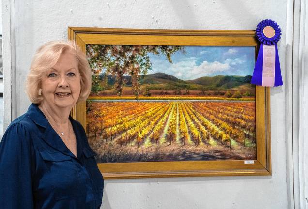 <b>Rita Joyce with her painting, which won a Critics Choice Award in the Art Show. (Photo by Nancy Madacsi)</b>