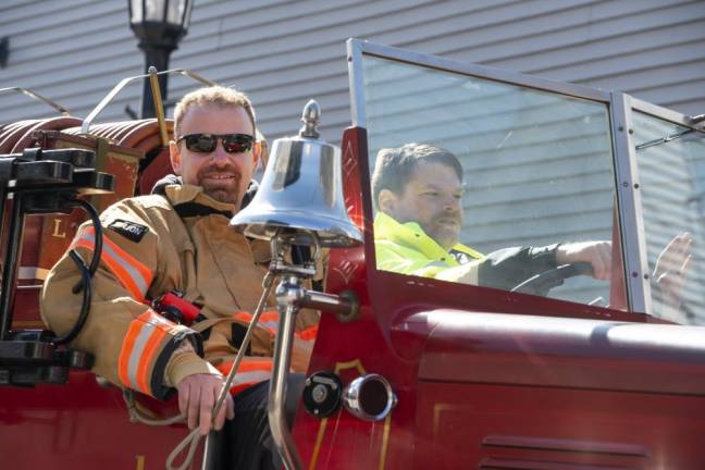 Firefighters ride in an antique Lafayette Township Fire Department truck.