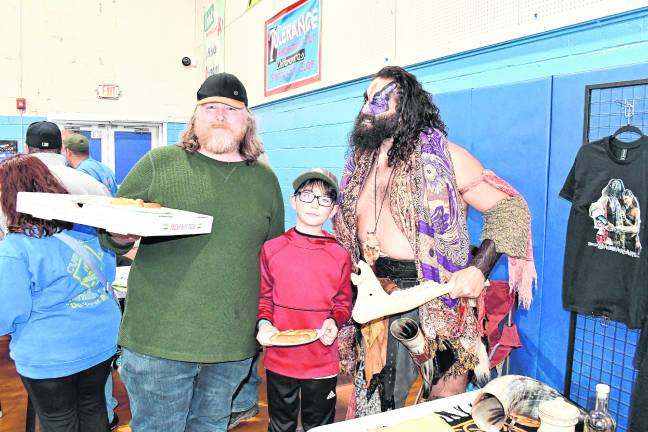 Rob Maloney ( holding pizza) and Reynaldo Sandoval, both of Vernon, pose with Yoscifer the Barbarian.