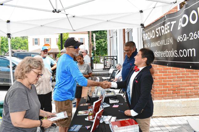 ZS2 Zy Saturnees, right, shakes hands with a fan.