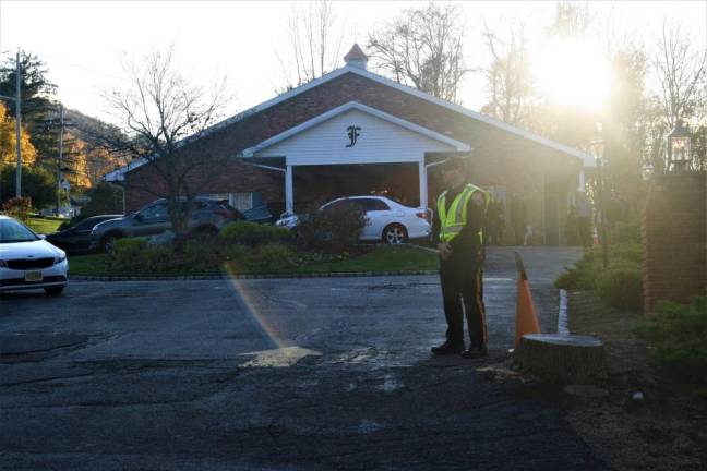 A police officer waits to direct traffic at Jordin Tenk's memorial at Ferguson-Vernon Funeral Home Saturday.