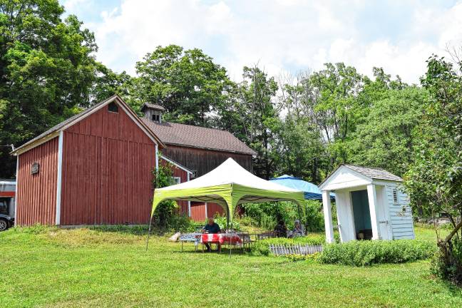 <b>A tent and outside seating are set up for lunch and treats between the ice barn and the privy.</b>