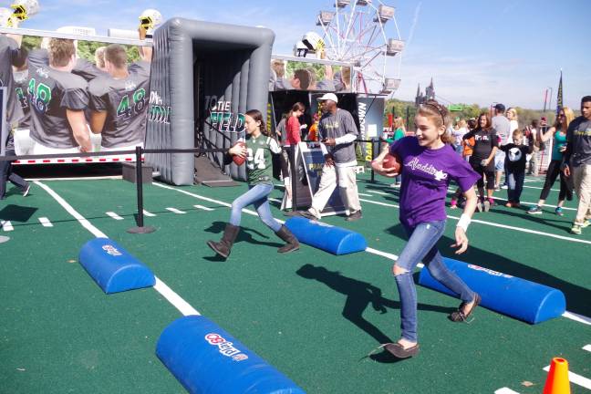 Obstacle course with vertical and horizontal obstacles representing standing and fallen players. The idea is to run the course with a football tucked under their arms.