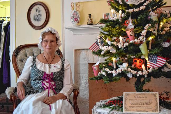 <b>DAR member Wendy Wyman tells visitors about a second-floor guest bedroom in the DAR Van Bunschooten Museum in Wantage. </b>