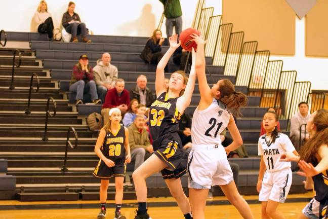 Jefferson's Alyssa Griswold's shot attempt is thwarted when the ball is slapped away by Sparta's Emily Dilger in the first quarter.