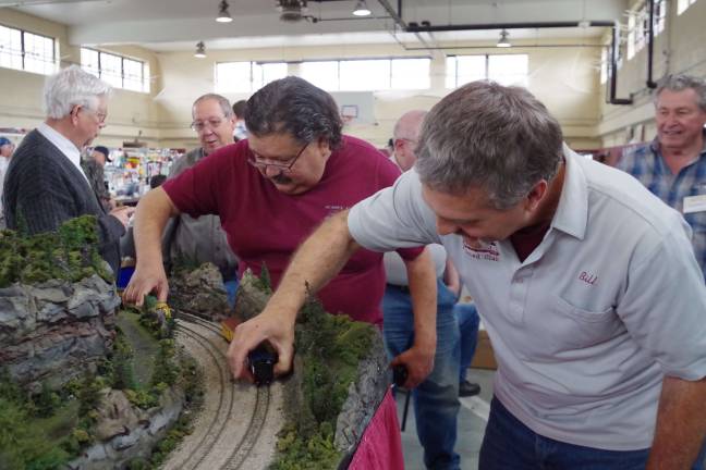 Photos by Chris Wyman From the left, club president John Bazelewich of Stockholm and member Bill Talmadge of Branchville put the errant railcars back on their tracks following the unexpected derailment.