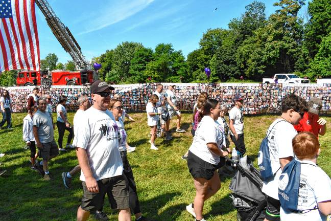 Participants walk past photos of those who died from addiction.