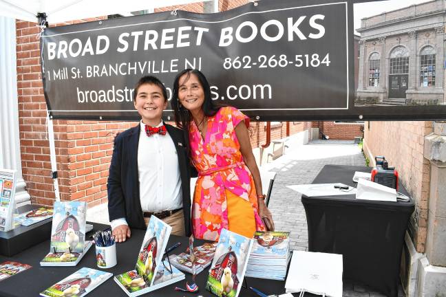 Sue-Ni DiStefano, co-owner of Broad Street Books, poses with young author Zy Saturnees.
