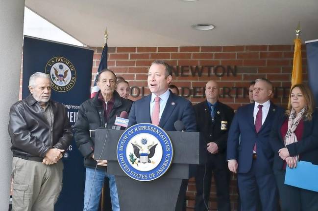 Rep. Josh Gottheimer, surrounded by local officials, speaks in front of the Newton municipal building.