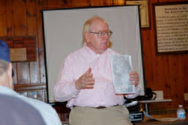 James Kane refers to a map of Korea as he tells the audience the reasons why the United States entered into an armed conflict with the North Korean government beginning in June 1950.